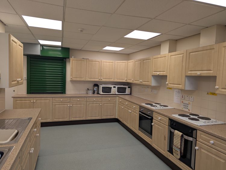 Kitchen with large range of appliances, direct access to the Youth wing along with 2 serving hatches