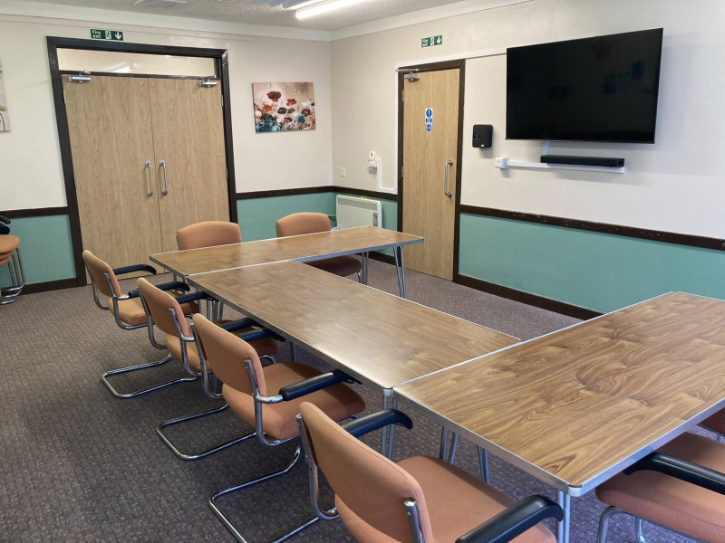 Weston Room - including screen, sound bar, seating up to 17 people, and access to the kitchen.